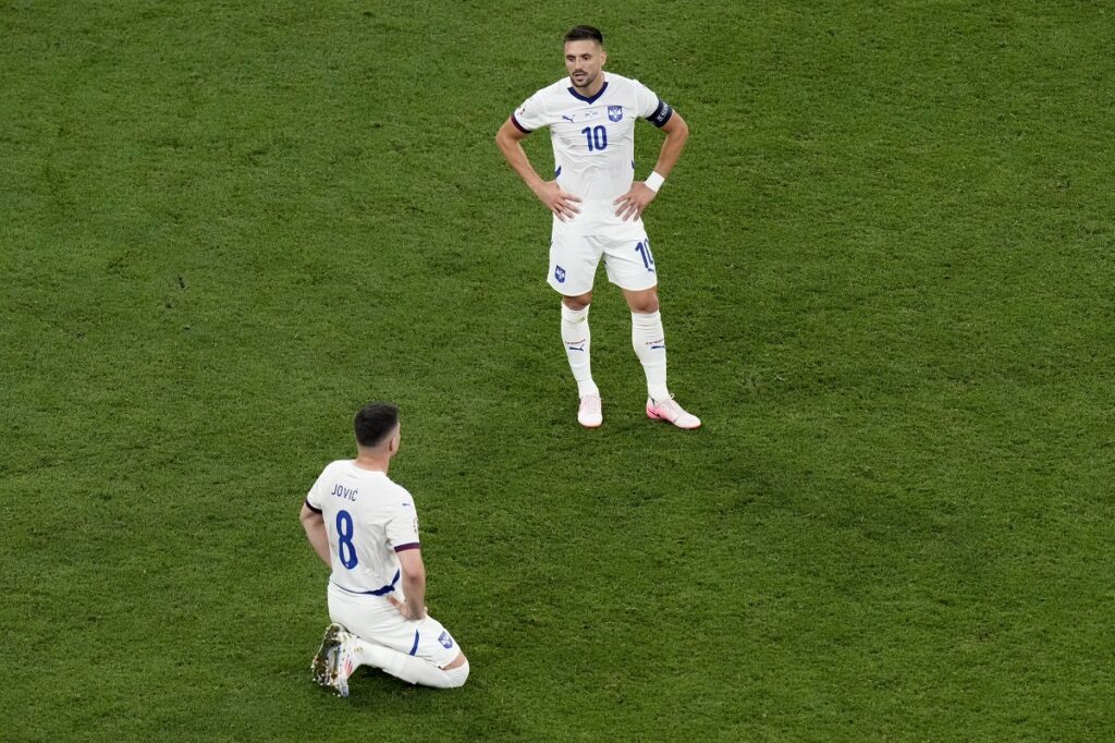 Serbia's Luka Jovic, left and Serbia's Dusan Tadic react after a Group C match between the Denmark and Serbia at the Euro 2024 soccer tournament in Munich, Germany, Tuesday, June 25, 2024. Left is Denmark's goalkeeper Kasper Schmeichel. (AP Photo/Ariel Schalit)