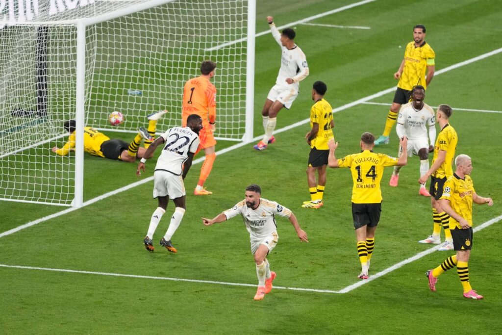 Real Madrid's Dani Carvajal, center, celebrates after scoring his side's opening goal during the Champions League final soccer match between Borussia Dortmund and Real Madrid at Wembley stadium in London, Saturday, June 1, 2024. (AP Photo/Alastair Grant)