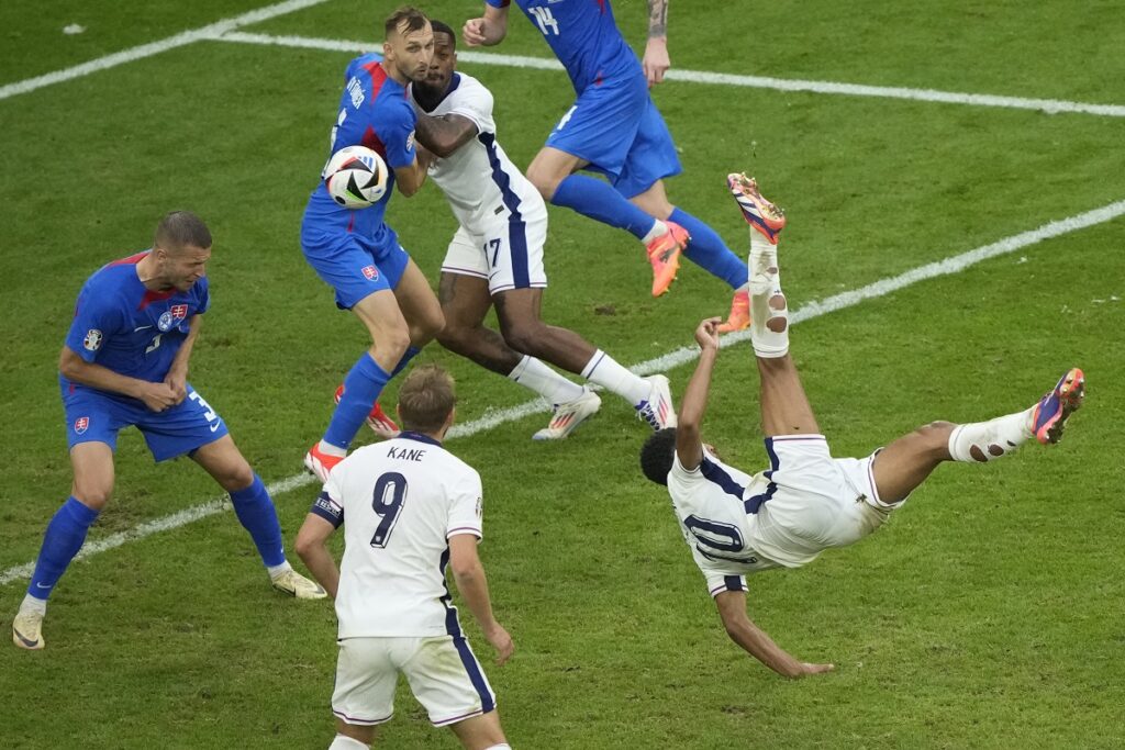 England's Jude Bellingham, right, scores his side's first goal with an overhead kick during a round of sixteen match between England and Slovakia at the Euro 2024 soccer tournament in Gelsenkirchen, Germany, Sunday, June 30, 2024. (AP Photo/Ebrahim Noroozi)