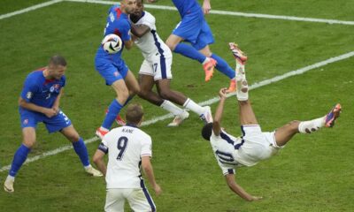 England's Jude Bellingham, right, scores his side's first goal with an overhead kick during a round of sixteen match between England and Slovakia at the Euro 2024 soccer tournament in Gelsenkirchen, Germany, Sunday, June 30, 2024. (AP Photo/Ebrahim Noroozi)