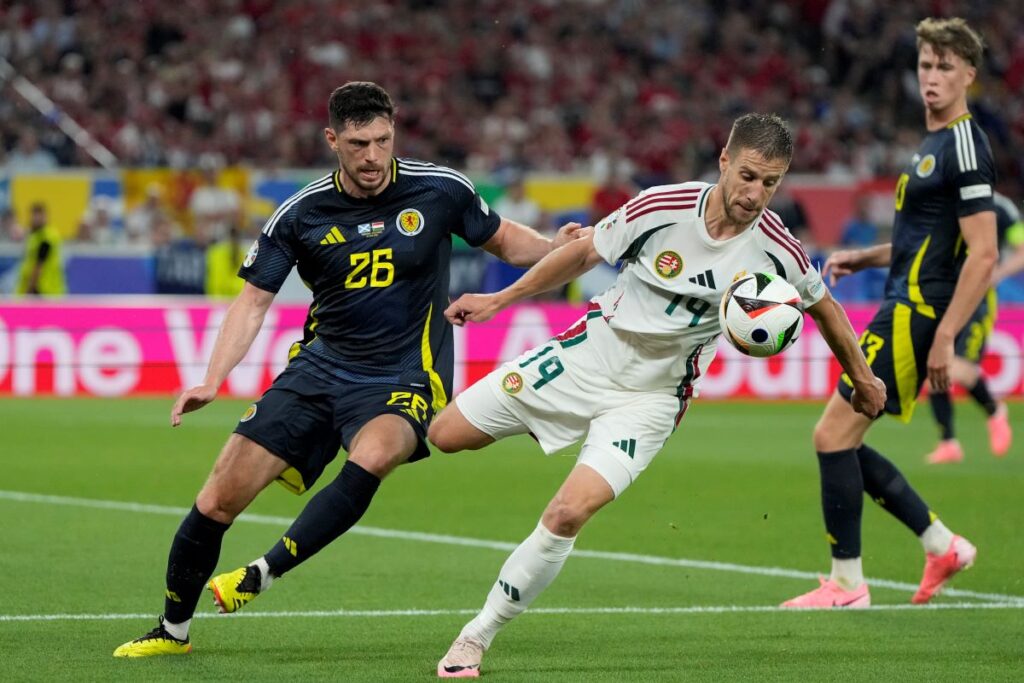 Scotland's Scott McKenna, left, and Hungary's Barnabas Varga, right, challenge for the ball during a Group A match between Scotland and Hungary at the Euro 2024 soccer tournament in Stuttgart, Germany, Sunday, June 23, 2024. (AP Photo/Matthias Schrader)
