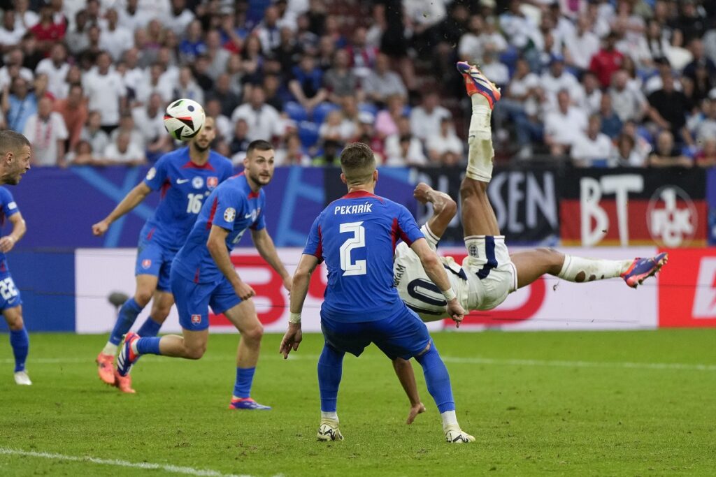 England's Jude Bellingham scores on a bicycle kick during a round of sixteen match between England and Slovakia at the Euro 2024 soccer tournament in Gelsenkirchen, Germany, Sunday, June 30, 2024. (AP Photo/Matthias Schrader)