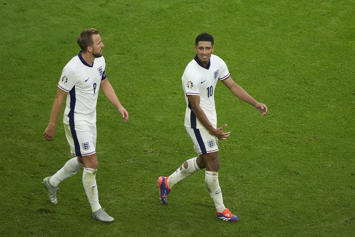 England's Jude Bellingham, right, reacts next to England's Harry Kane after scoring his side's opening goal during a round of sixteen match between England and Slovakia at the Euro 2024 soccer tournament in Gelsenkirchen, Germany, Sunday, June 30, 2024. (AP Photo/Ebrahim Noroozi)