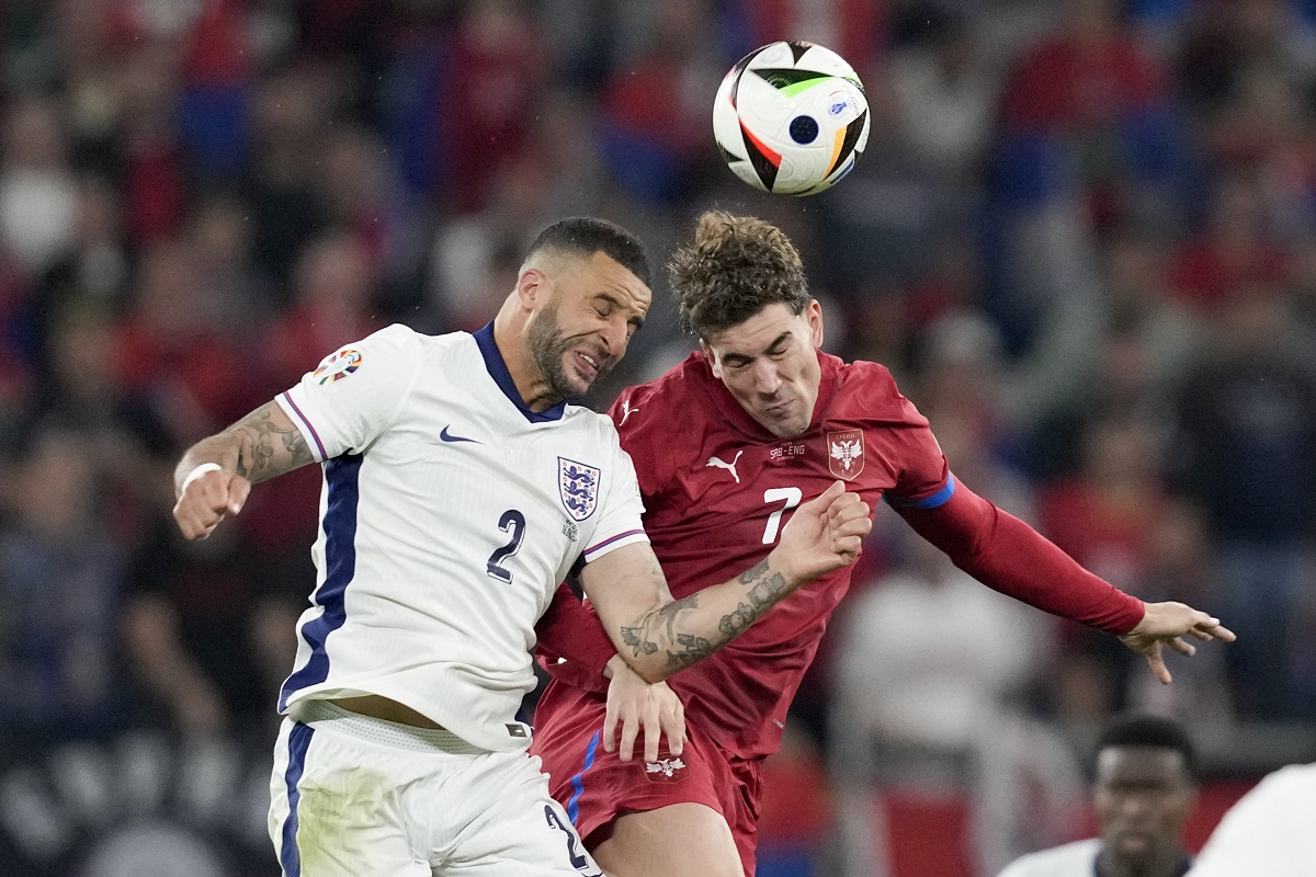 England's Kyle Walker, left, vies for a header next to Serbia's Dusan Vlahovic during the second half in a Group C match between Serbia and England at the Euro 2024 soccer tournament in Gelsenkirchen, Germany, Monday, June 17, 2024. (AP Photo/Thanassis Stavrakis)