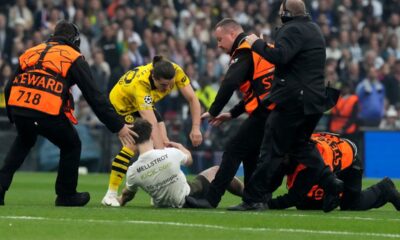 Dortmund's Marcel Sabitzer, center, and stewards chase a pitch invader during the Champions League final soccer match between Borussia Dortmund and Real Madrid at Wembley stadium in London, Saturday, June 1, 2024. (AP Photo/Frank Augstein)