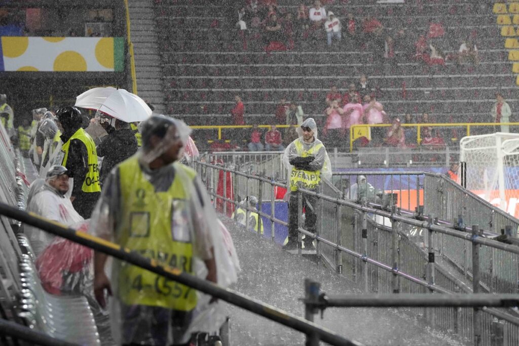 Heavy rain falls as stewards await the start of a Group F match between Turkey and Georgia at the Euro 2024 soccer tournament in Dortmund, Germany, Tuesday, June 18, 2024. (AP Photo/Martin Meissner)
