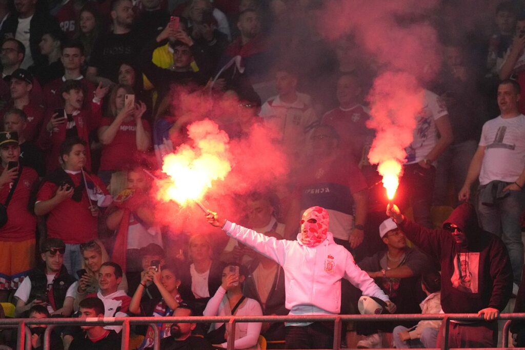 FILE - Serbia fans lit flares during an international friendly soccer match between Austria and Serbia at the Ernst Happel Stadion in Vienna, Austria, Tuesday, June 4, 2024. A recent surge in violence around soccer games is contributing to alarm over security when Germany hosts the European Championship. (AP Photo/Matthias Schrader, File)