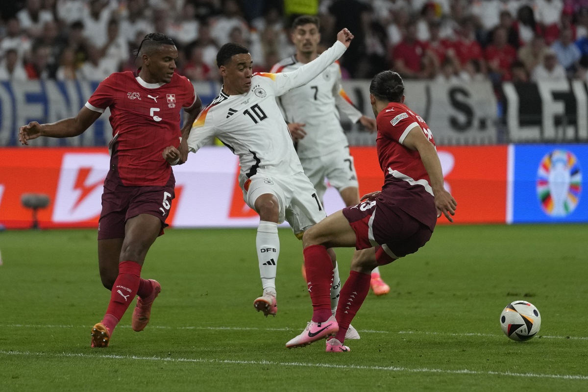 Switzerland's Manuel Akanji, left, challenges Germany's Jamal Musiala during a Group A match between Switzerland and Germany at the Euro 2024 soccer tournament in Frankfurt, Germany, Sunday, June 23, 2024. (AP Photo/Darko Vojinovic)