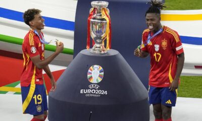 Spain's Lamine Yamal, left, and Nico Williams celebrate at the podium during the final match against England at the Euro 2024 soccer tournament in Berlin, Germany, Sunday, July 14, 2024. Spain won the game 2-1. (AP Photo/Thanassis Stavrakis)