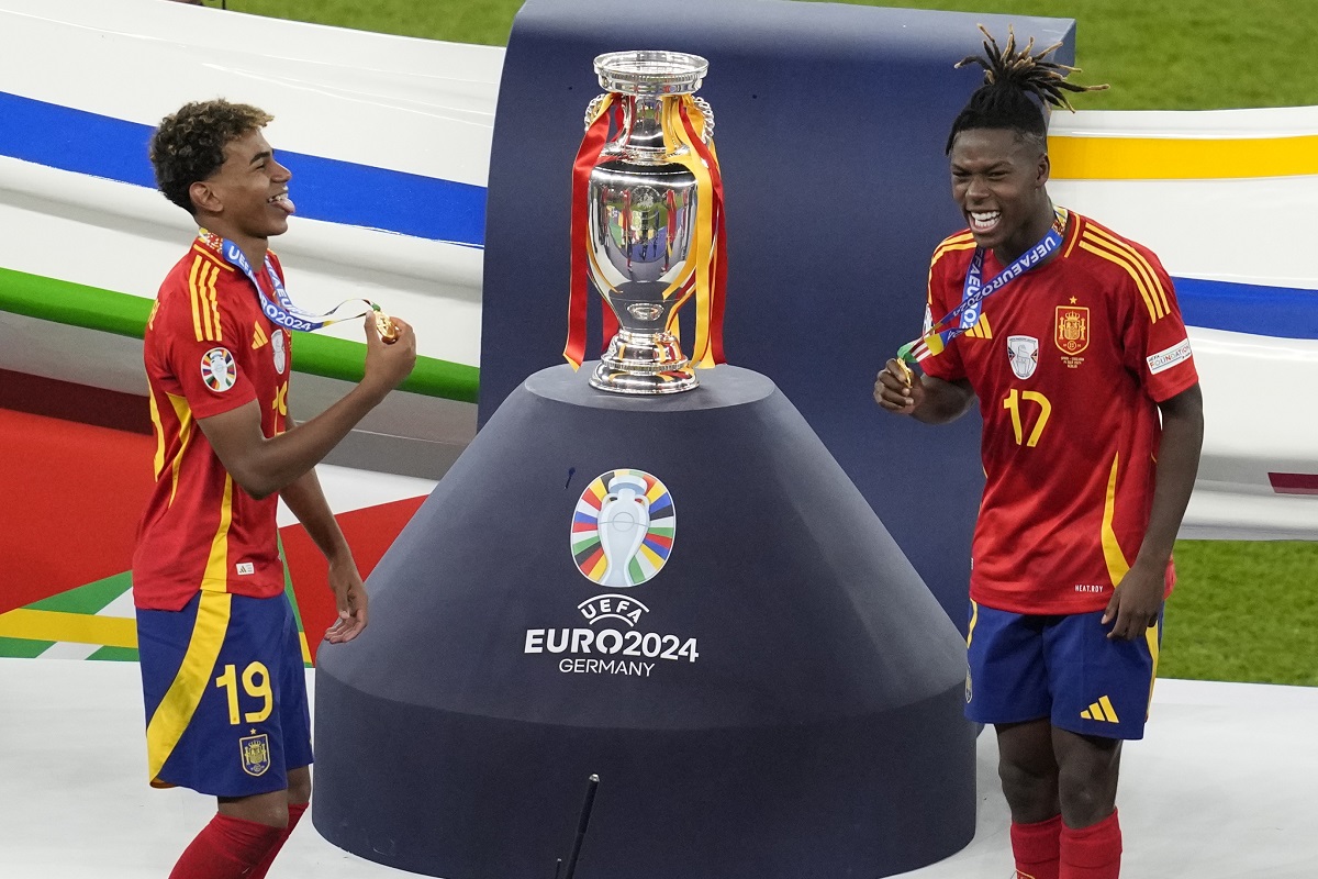 Spain's Lamine Yamal, left, and Nico Williams celebrate at the podium during the final match against England at the Euro 2024 soccer tournament in Berlin, Germany, Sunday, July 14, 2024. Spain won the game 2-1. (AP Photo/Thanassis Stavrakis)