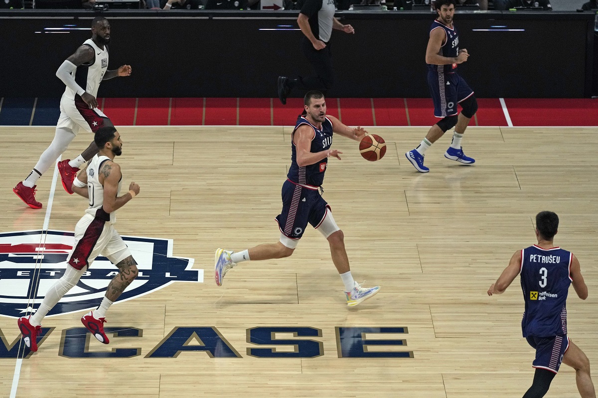 Serbia's Nikola Jokic, center, collects a pass during an exhibition basketball match between Serbia and the United States at the USA Basketball Showcase, ahead of the 2024 Paris Olympic basketball tournament, in Abu Dhabi, United Arab Emirates, Wednesday, July 17, 2024. (AP Photo/Altaf Qadri)