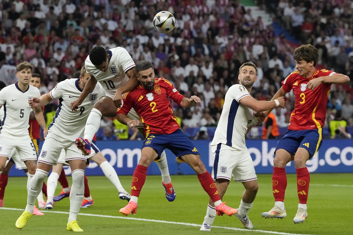 England's Jude Bellingham, top, jumps for the ball with Spain's Dani Carvajal during the final match between Spain and England at the Euro 2024 soccer tournament in Berlin, Germany, Sunday, July 14, 2024. (AP Photo/Frank Augstein)