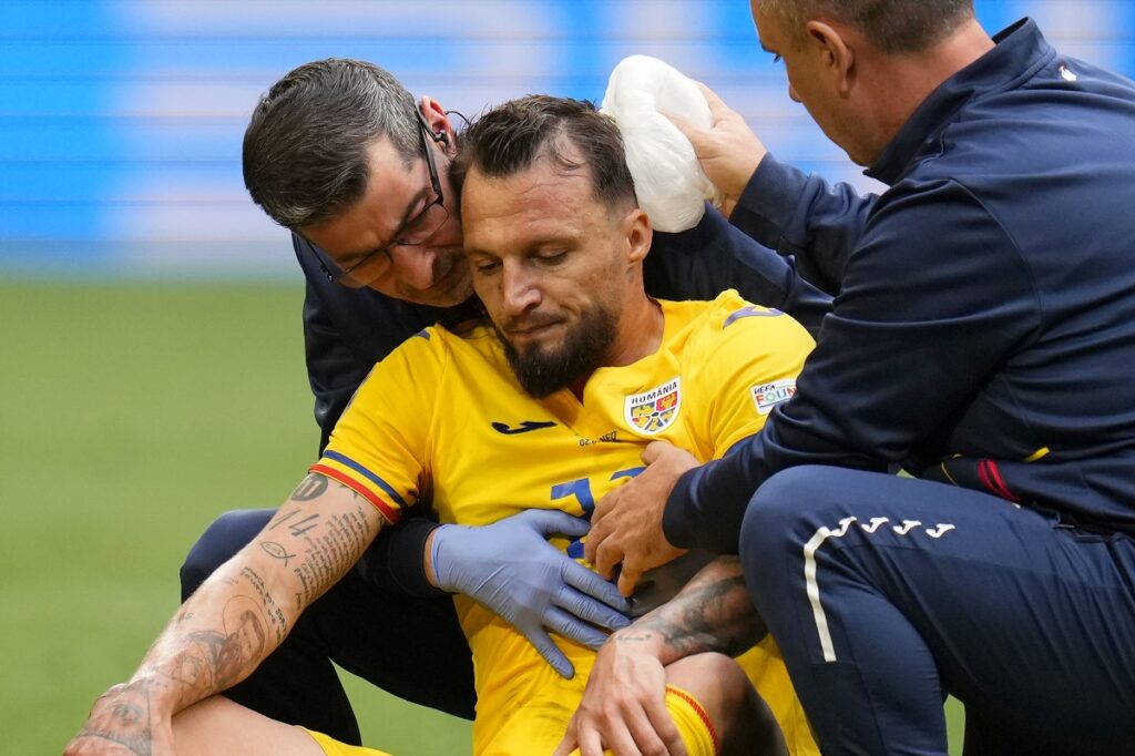 Romania's Vasile Mogos is assisted after getting injured having to be substituted during a round of sixteen match between Romania and the Netherlands at the Euro 2024 soccer tournament in Munich, Germany, Tuesday, July 2, 2024. (AP Photo/Manu Fernandez)