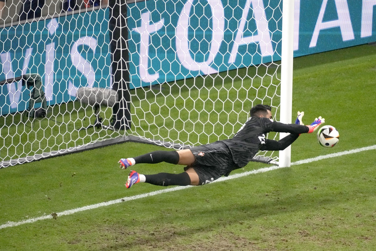 Portugal's goalkeeper Diogo Costa saves the ball during penalties of a round of sixteen match between Portugal and Slovenia at the Euro 2024 soccer tournament in Frankfurt, Germany, Monday, July 1, 2024. (AP Photo/Michael Probst)