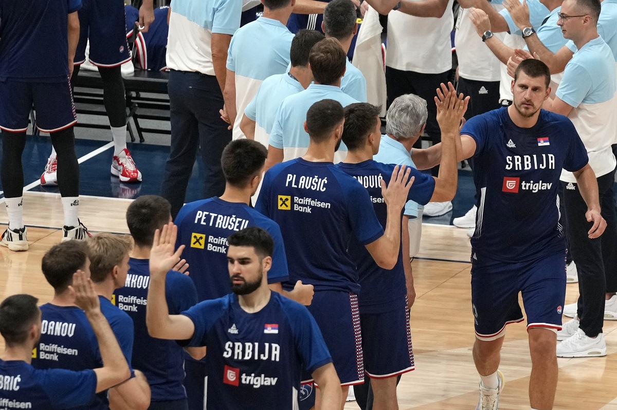 Serbia's Nikola Jokic, right, greets teammates as he enters the court to play an exhibition basketball match between Serbia and the United States at the USA Basketball Showcase, ahead of the 2024 Paris Olympic basketball tournament, in Abu Dhabi, United Arab Emirates, Wednesday, July 17, 2024. (AP Photo/Altaf Qadri)