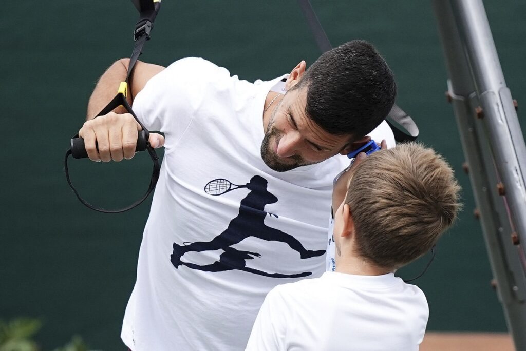 Serbia's Novak Djokovic reacts with his son, during a training session, a day ahead of his Men's singles final match against Spain's Carlos Alcaraz at the Wimbledon tennis championships, in London, Saturday, July 13, 2024. (Aaron Chown/PA via AP)