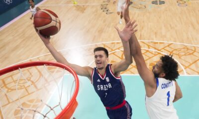 Filip Petrusev, of Serbia, shoots around dGeorge Conditt IV, of Puerto Rico, in a men's basketball game in a men's basketball game at the 2024 Summer Olympics, Wednesday, July 31, 2024, in Villeneuve-d'Ascq, France. (AP Photo/Mark J. Terrill, Pool)