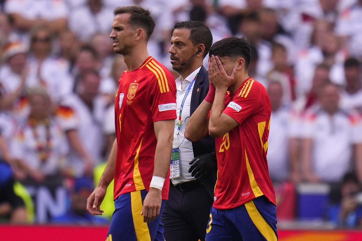 Spain's Pedri, right, covers his face after suffering an injury during a quarter final match between Germany and Spain at the Euro 2024 soccer tournament in Stuttgart, Germany, Friday, July 5, 2024. (AP Photo/Manu Fernandez)