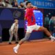 Serbian tennis player Novak Djokovic returns the ball against Matthew Ebden of Australia during the men's singles tennis competition, at the 2024 Summer Olympics, Saturday, July 27, 2024, in Paris, France. (AP Photo/Manu Fernandez)