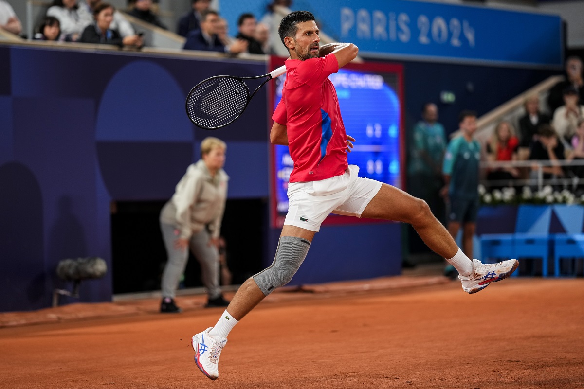 Serbian tennis player Novak Djokovic returns the ball against Matthew Ebden of Australia during the men's singles tennis competition, at the 2024 Summer Olympics, Saturday, July 27, 2024, in Paris, France. (AP Photo/Manu Fernandez)