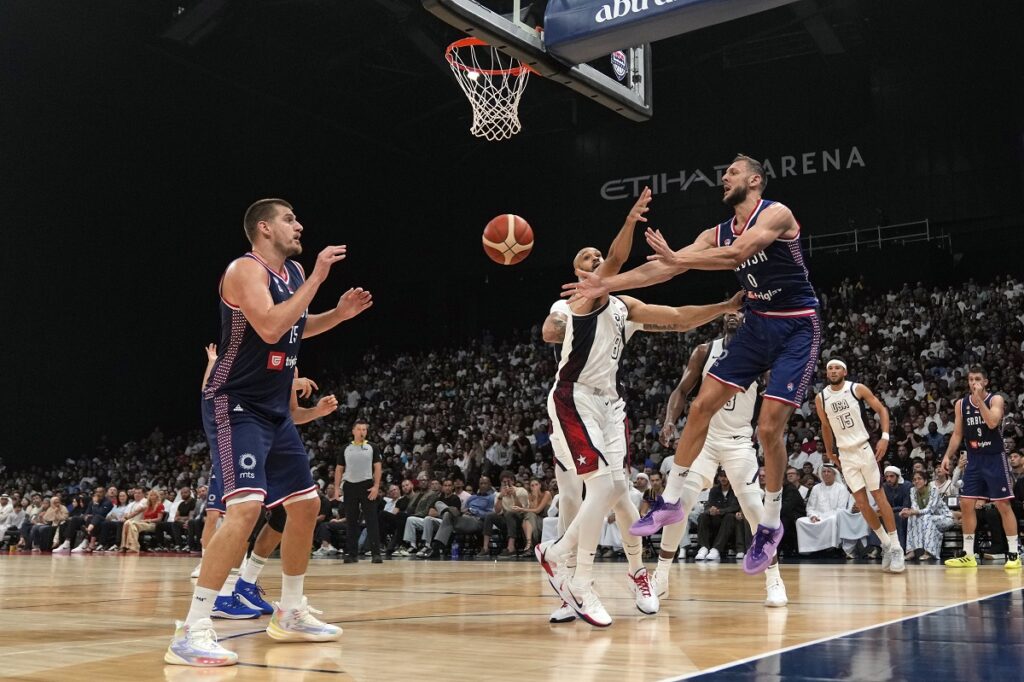 Serbia's Uro s Plavsic, right, passes the ball to Serbia's Nikola Jokic, left, during an exhibition basketball match between Serbia and the United States at the USA Basketball Showcase, ahead of the 2024 Paris Olympic basketball tournament, in Abu Dhabi, United Arab Emirates, Wednesday, July 17, 2024. (AP Photo/Altaf Qadri)