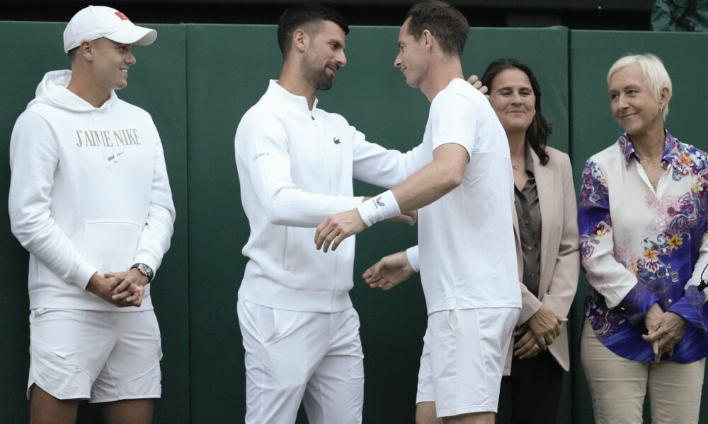 Britain's Andy Murray reacts with Serbia's Novak Djokovic, second left, as Holger Rune, left, of Denmark, and Conchita Martinez of Spain, and Martina Navratilova, right, of the US watch following his first round doubles match at the Wimbledon tennis championships in London, Thursday, July 4, 2024. (AP Photo/Kirsty Wigglesworth)