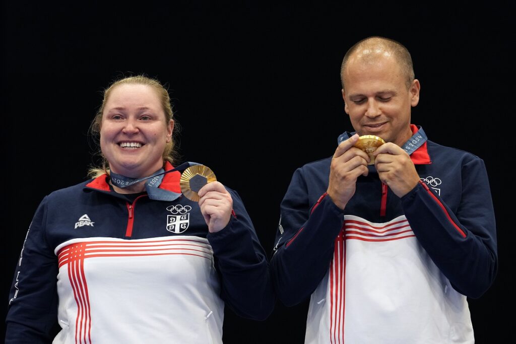 Serbia's Zorana Arunovic, left, and Serbia's Damir Mikec pose for a photograph after winning the gold medal in the 10m air pistol mixed team event at the 2024 Summer Olympics, Tuesday, July 30, 2024, in Chateauroux, France. (AP Photo/Manish Swarup)