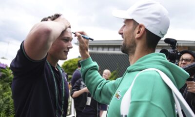 Serbia's Novak Djokovic signs a fan's forehead as he makes his way to a training session, a day ahead of his Men's singles final match against Spain's Carlos Alcaraz at the Wimbledon tennis championships, in London, Saturday, July 13, 2024. (Aaron Chown/PA via AP)