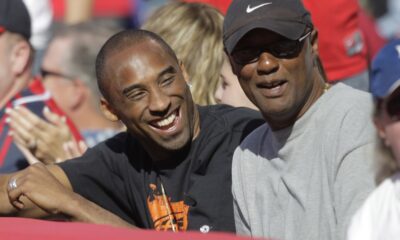 FILE - Los Angeles Lakers' Kobe Bryant, left, talks to his father, Joe, as they watch a baseball game between the Los Angeles Angels and the Los Angeles Dodgers in Anaheim, Calif., Sunday, June 21, 2009. Joe “Jellybean” Bryant has died, his alma mater announced Tuesday, July 16, 2024. Joe Bryant, who spent eight seasons in the NBA with three different franchises, was 69. The Philadelphia Inquirer, citing La Salle coach Fran Dunphy, reported that Joe Bryant recently had a massive stroke. (AP Photo/Jae C. Hong, File)