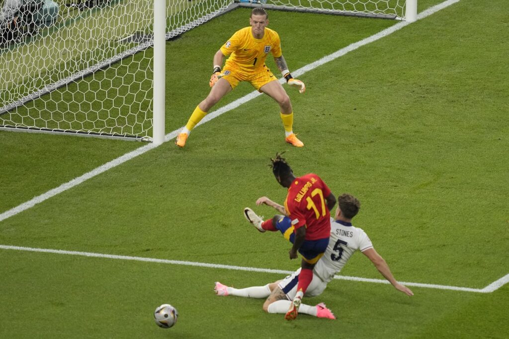 England's John Stones blocks the shot of Spain's Nico Williams during the final match between Spain and England at the Euro 2024 soccer tournament in Berlin, Germany, Sunday, July 14, 2024. (AP Photo/Andreea Alexandru)