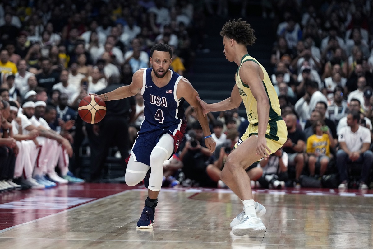 Team USA's Stephen Curry (4) drives on Australia's Dyson Daniels during the USA Basketball Showcase in Abu Dhabi, United Arab Emirates, Monday, July 15, 2024. (AP Photo/Altaf Qadri)