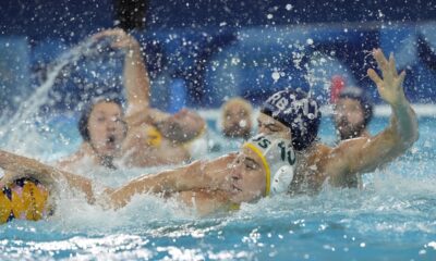 Serbia's Petar Jaksic, right, battles for the ball against Australia's Marcus Berehulak, during a men's water polo Group B preliminary match between Australia and Serbia at the 2024 Summer Olympics, Tuesday, July 30, 2024, in Saint-Denis, France. (AP Photo/Luca Bruno)