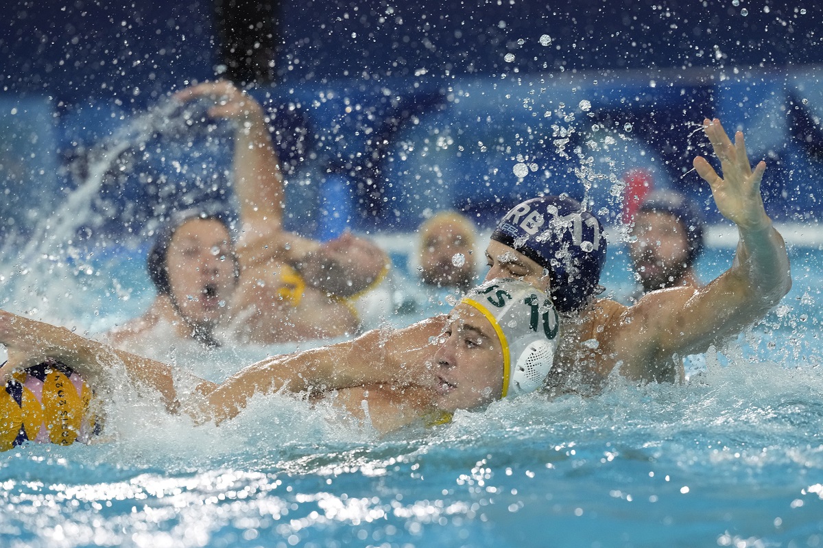 Serbia's Petar Jaksic, right, battles for the ball against Australia's Marcus Berehulak, during a men's water polo Group B preliminary match between Australia and Serbia at the 2024 Summer Olympics, Tuesday, July 30, 2024, in Saint-Denis, France. (AP Photo/Luca Bruno)