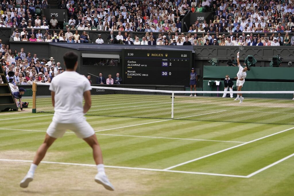 Novak Djokovic of Serbia serves to Carlos Alcaraz of Spain during the men's singles final at the Wimbledon tennis championships in London, Sunday, July 14, 2024. (AP Photo/Alberto Pezzali)