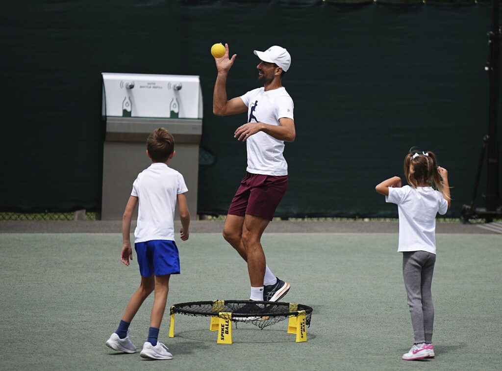 Serbia's Novak Djokovic plays a game of Spike Ball with his children before training, at the Wimbledon tennis championships in London, Saturday, July 13, 2024. (Aaron Chown/PA via AP)