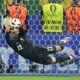 Portugal's goalkeeper Diogo Costa saves the ball during penalties of a round of sixteen match between Portugal and Slovenia at the Euro 2024 soccer tournament in Frankfurt, Germany, Monday, July 1, 2024. (AP Photo/Ebrahim Noroozi)