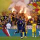 Virgil van Dijk of the Netherlands, center, runs while Romania supporters light flares on the stands during a round of sixteen match between Romania and the Netherlands at the Euro 2024 soccer tournament in Munich, Germany, Tuesday, July 2, 2024. (AP Photo/Manu Fernandez)