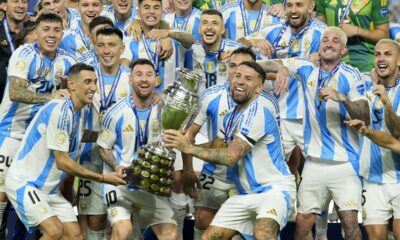 Argentina players Angel di Maria, left, Lionel Messi, second from left, and Nicolas Otamendi, third from left, celebrate with the trophy after defeating Colombia in the Copa America final soccer match in Miami Gardens, Fla., Monday, July 15, 2024. (AP Photo/Rebecca Blackwell)