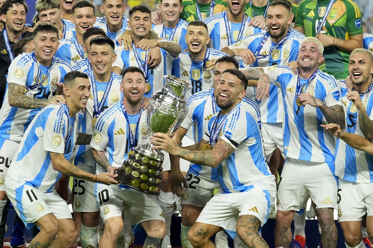 Argentina players Angel di Maria, left, Lionel Messi, second from left, and Nicolas Otamendi, third from left, celebrate with the trophy after defeating Colombia in the Copa America final soccer match in Miami Gardens, Fla., Monday, July 15, 2024. (AP Photo/Rebecca Blackwell)