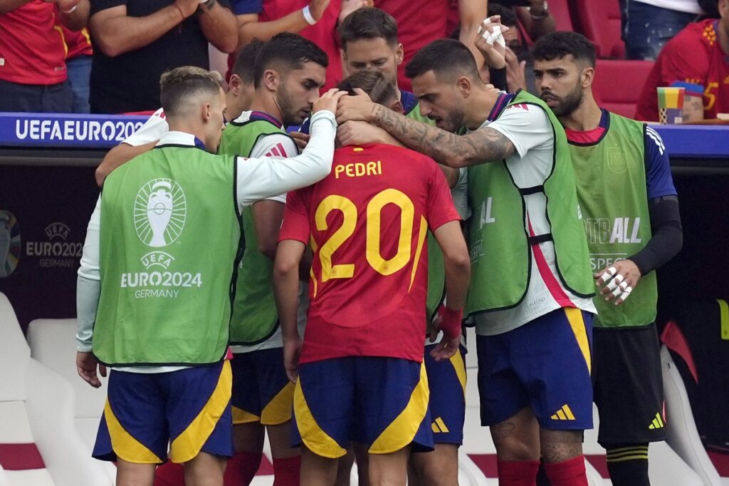 Spain's Pedri (20) is consoled by teammates after he was taken out of the game following an injury in a quarterfinal match between Germany and Spain at the Euro 2024 soccer tournament in Stuttgart, Germany, Friday, July 5, 2024. (AP Photo/Antonio Calanni)