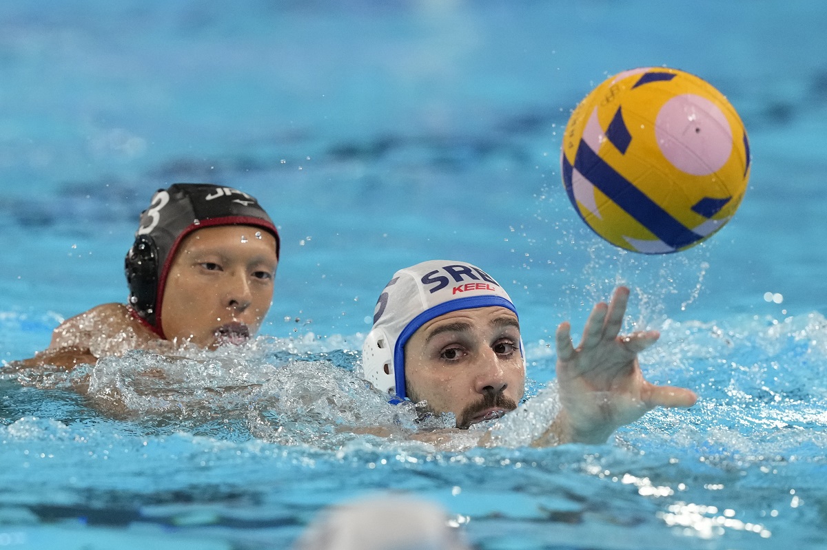 Serbia's Milos Cuk, right, and Japan's Taiyo Watanabe battle for the ball during the men's Water Polo Group B preliminary match between Serbia and Japan at the 2024 Summer Olympics, Sunday, July 28, 2024, in Saint-Denis, France. (AP Photo/Luca Bruno)