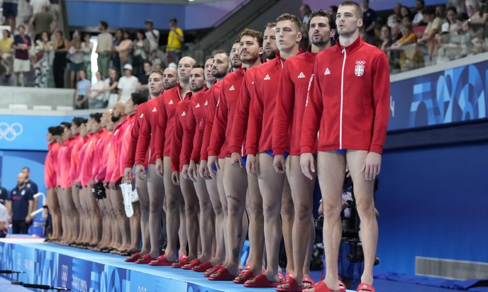 Serbia players listen their national anthem prior to the men's Water Polo Group B preliminary match between Serbia and Japan at the 2024 Summer Olympics, Sunday, July 28, 2024, in Saint-Denis, France. (AP Photo/Luca Bruno)