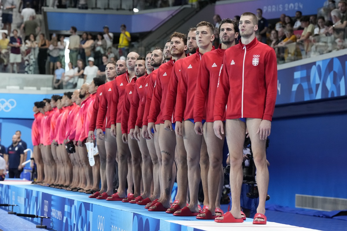 Serbia players listen their national anthem prior to the men's Water Polo Group B preliminary match between Serbia and Japan at the 2024 Summer Olympics, Sunday, July 28, 2024, in Saint-Denis, France. (AP Photo/Luca Bruno)