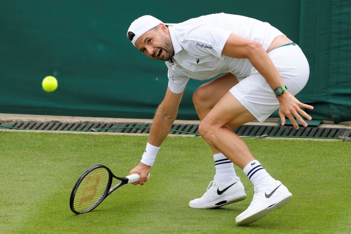 Grigor Dimitrov of Bulgaria plays a forehand return to Dusan Lajovic of Serbia during their first round match of the Wimbledon tennis championships in London, Monday, July 1, 2024. (AP Photo/Kirsty Wigglesworth)