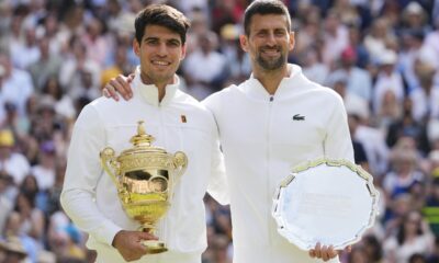 Carlos Alcaraz, left, of Spain holds his trophy after defeating Novak Djokovic, right, of Serbia in the men's singles final at the Wimbledon tennis championships in London, Sunday, July 14, 2024.(AP Photo/Kirsty Wigglesworth)