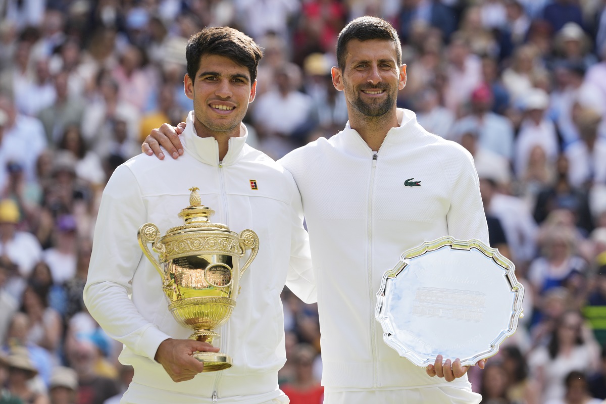 Carlos Alcaraz, left, of Spain holds his trophy after defeating Novak Djokovic, right, of Serbia in the men's singles final at the Wimbledon tennis championships in London, Sunday, July 14, 2024.(AP Photo/Kirsty Wigglesworth)