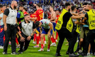 Spain's Alvaro Morata, centre, holds his leg after an incident with an invader after a semifinal match between Spain and France at the Euro 2024 soccer tournament in Munich, Germany, Tuesday, July 9, 2024. Left Spain's Rodri. (AP Photo/Hassan Ammar)