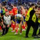 Spain's Alvaro Morata, centre, holds his leg after an incident with an invader after a semifinal match between Spain and France at the Euro 2024 soccer tournament in Munich, Germany, Tuesday, July 9, 2024. Left Spain's Rodri. (AP Photo/Hassan Ammar)