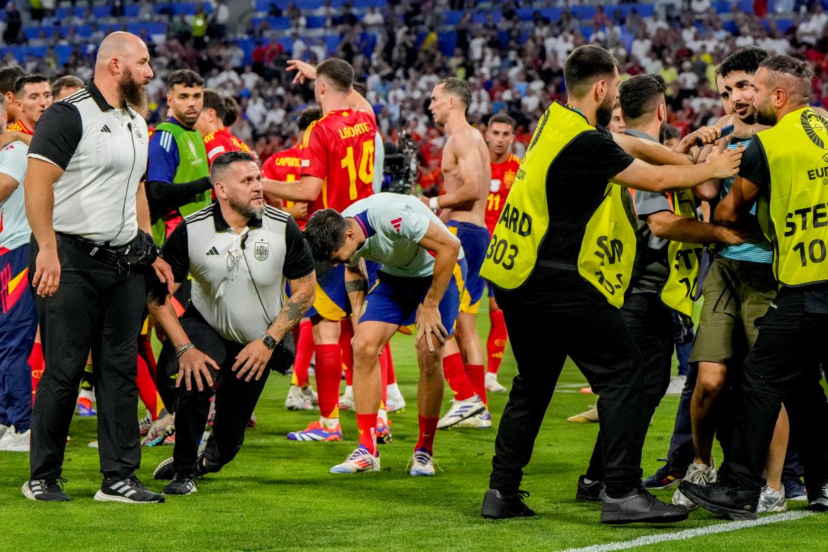 Spain's Alvaro Morata, centre, holds his leg after an incident with an invader after a semifinal match between Spain and France at the Euro 2024 soccer tournament in Munich, Germany, Tuesday, July 9, 2024. Left Spain's Rodri. (AP Photo/Hassan Ammar)