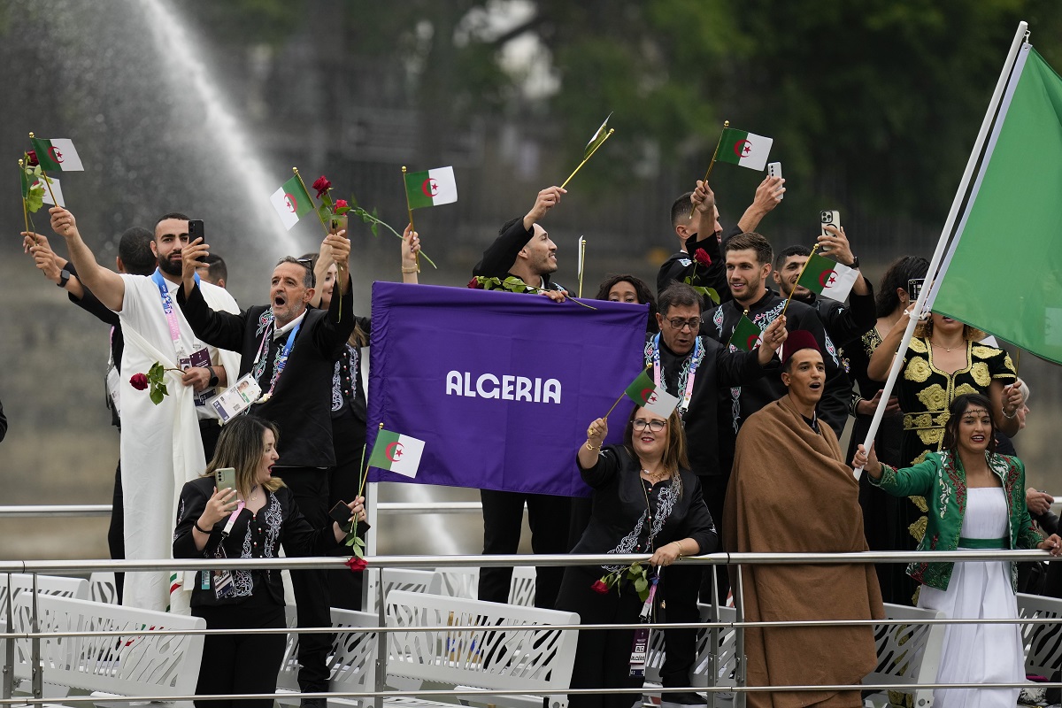 Team Algeria wave flags in Paris, France, during the opening ceremony of the 2024 Summer Olympics, Friday, July 26, 2024. (AP Photo/Kirsty Wigglesworth)